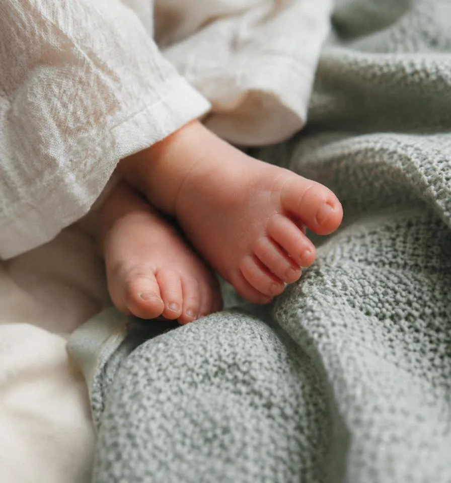 Baby feet on a mint knit blanket