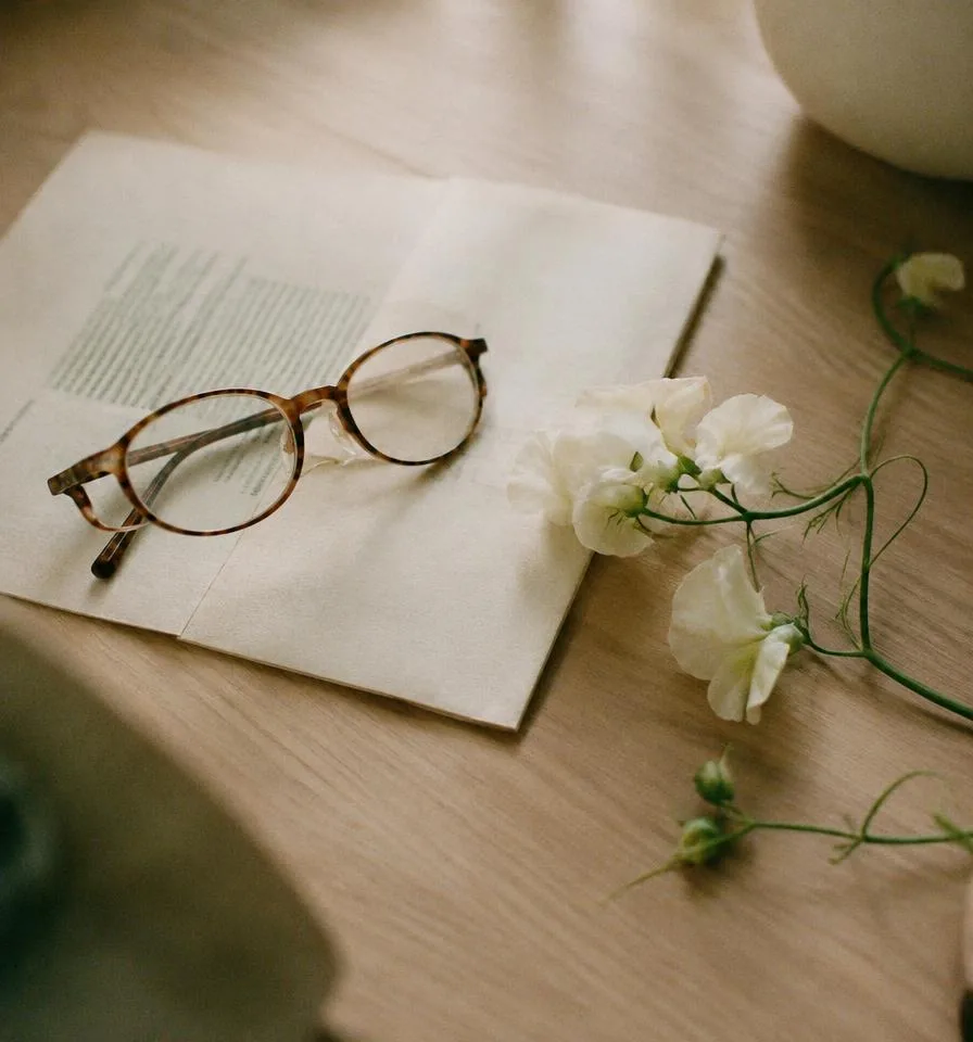 Reading glasses on a folded document on oak